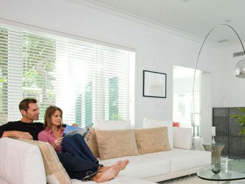 Motorized shades covering windows in a bright living room
